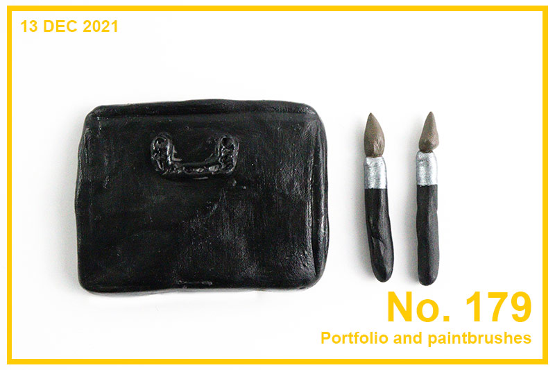 Portfolio review image with a miniature art portfolio and two paintbrushes